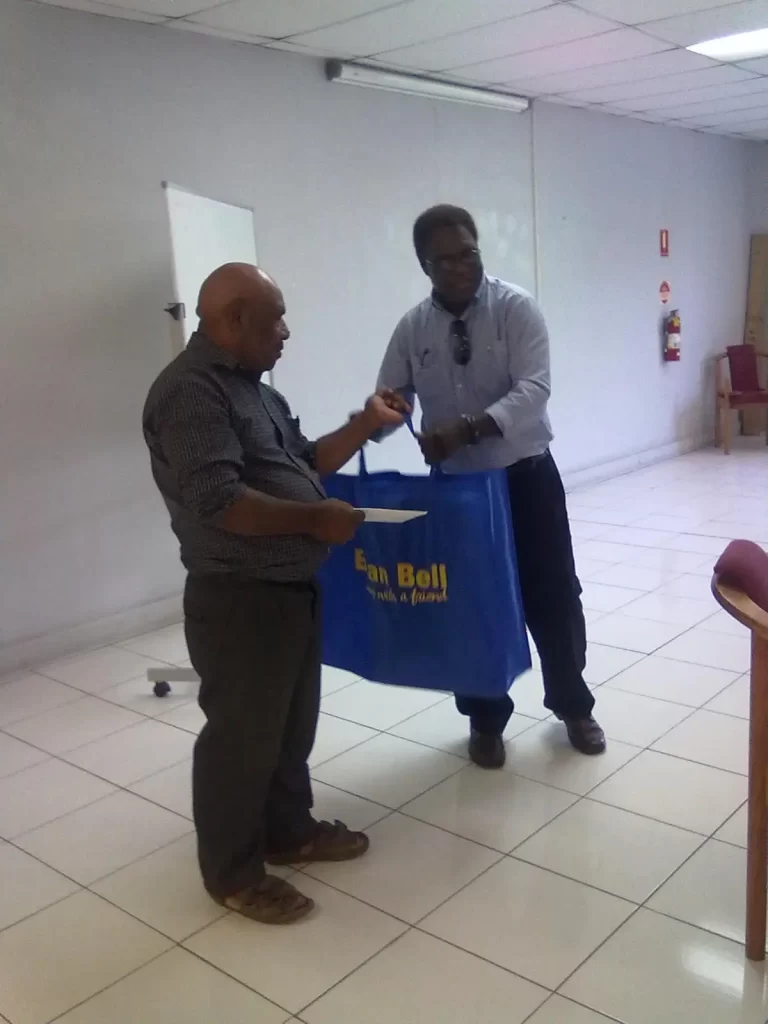 John Iso (left) receiving a gift from Dr. Tagis, who also informed the staff that Iso will also be receiving an official gift from the office
